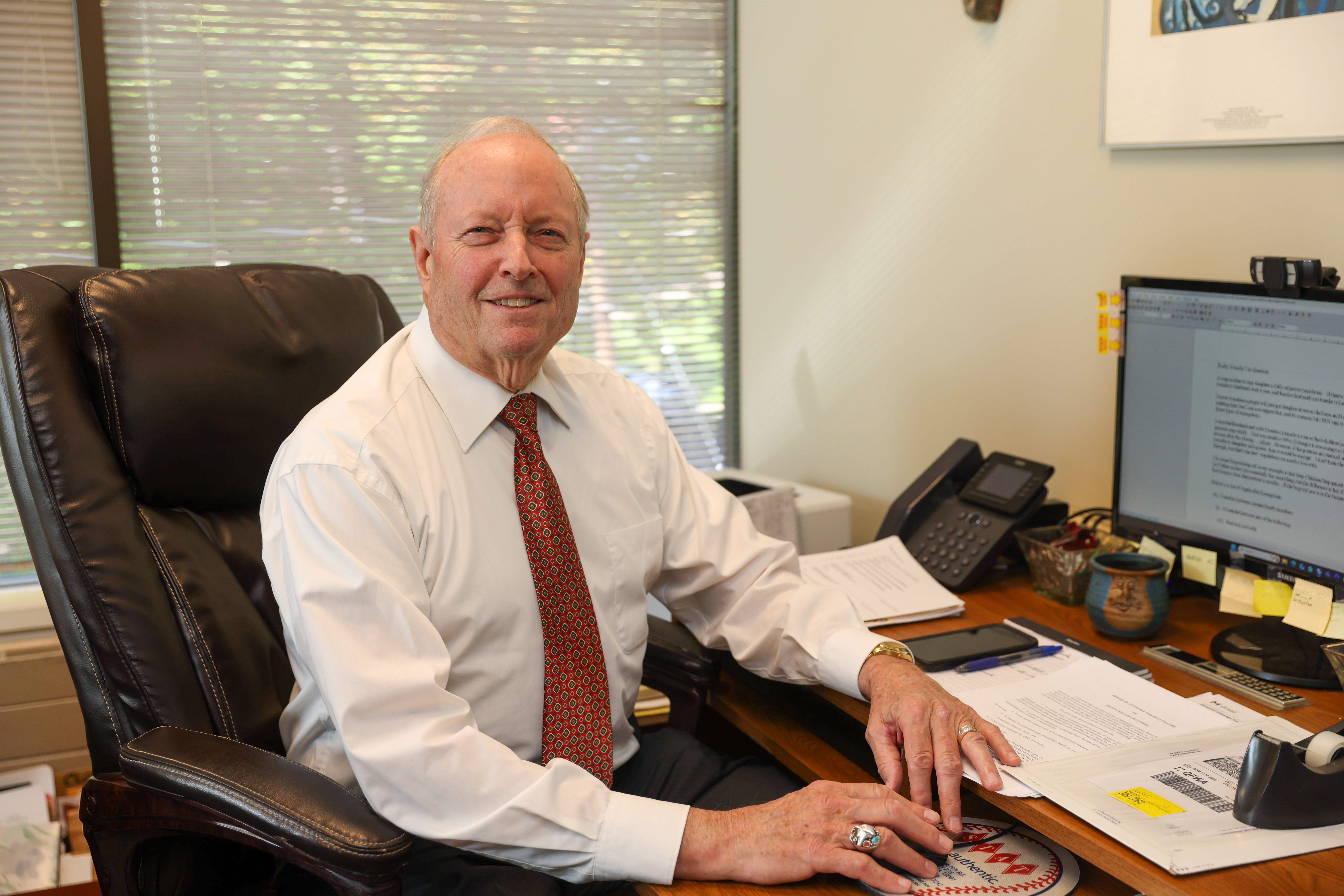 Robert W. Maher wearing a black suit with a red tie
